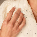 Load image into Gallery viewer, Close-up of a hand wearing two gold rings on a blurred background
