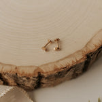 Load image into Gallery viewer, Gold stud earrings on a wooden surface with a neutral background
