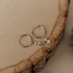 Load image into Gallery viewer, Silver earrings with small diamonds on a wooden surface
