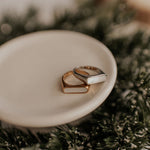 Load image into Gallery viewer, Two gold rings on a white dish with a blurred background
