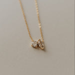 Load image into Gallery viewer, Gold necklace with a diamond pendant on a neutral background
