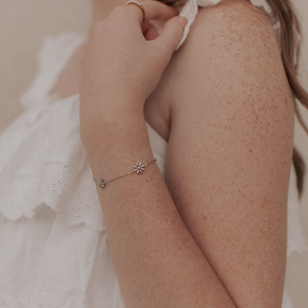 Person wearing a delicate bracelet with a blurred background