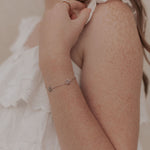 Load image into Gallery viewer, Person wearing a delicate bracelet with a blurred background
