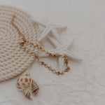 bracelet with a shell pendant on a textured surface