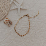 Load image into Gallery viewer, Gold bracelet on a textured beige surface with starfish and rope
