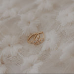 Gold star earrings on a textured white fabric background