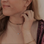 Load image into Gallery viewer, Woman adjusting her earring with a neutral background

