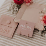 Load image into Gallery viewer, Mauve jewelry pouch and card on a striped fabric background with flowers.
