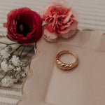 Gold ring on a decorative plate with red and pink flowers
