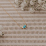 Load image into Gallery viewer, Necklace with a turquoise pendant on a striped fabric background

