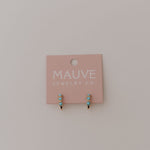 Pink jewelry card with turquoise and gold hoop earrings on a light gray background