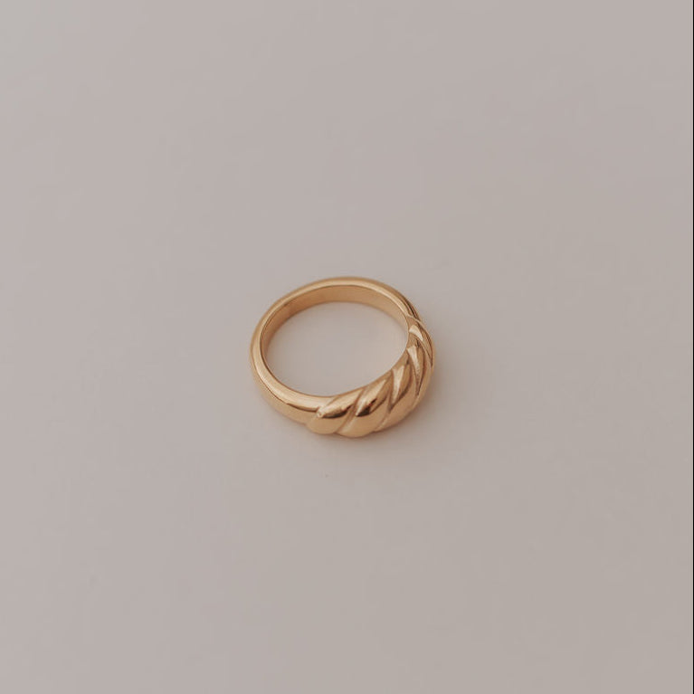 Gold ring on a light gray background