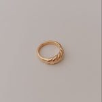 Gold ring on a light gray background