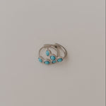 Silver earrings with turquoise stones on a light gray background