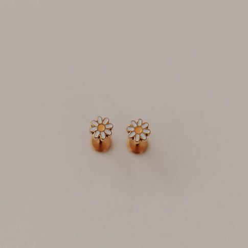 Pair of gold daisy flat back earrings on a light gray background
