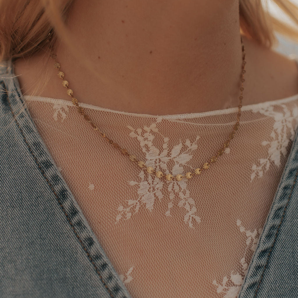 Close-up of a necklace with floral design on a sheer fabric background