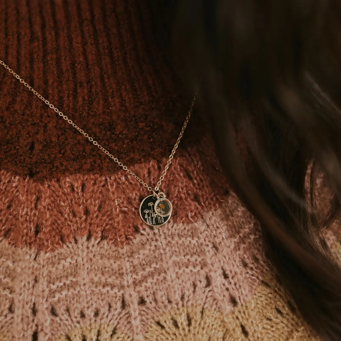 Necklace with a pendant on a textured brown sweater