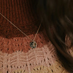 Necklace with a pendant on a textured brown sweater
