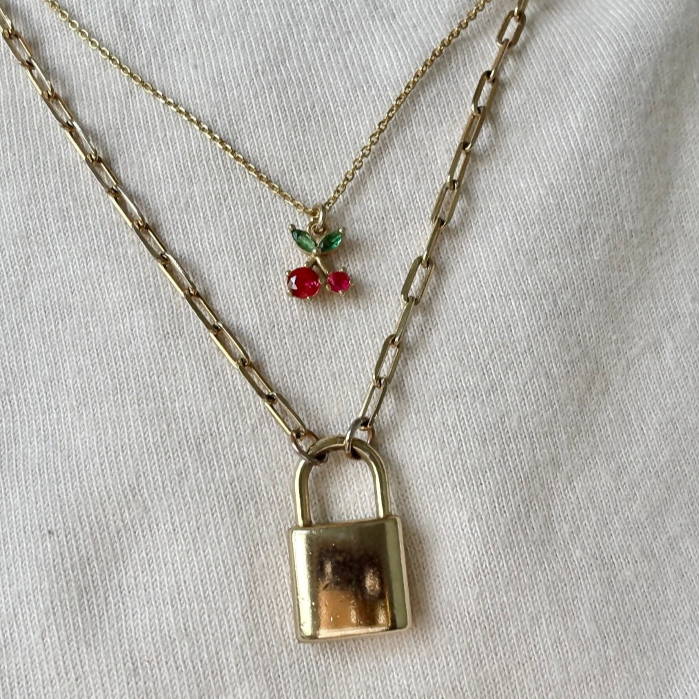Necklace with a padlock charm and red berries on a white background