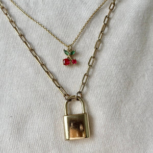 Necklace with a padlock charm and red berries on a white background