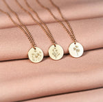Load image into Gallery viewer, Three gold necklaces with engraved pendants on a pink fabric background

